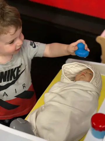 Tucking a baby doll into the bassinet