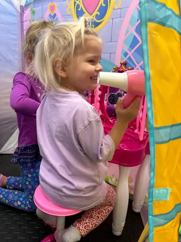 A child playing inside the fabric playhouse