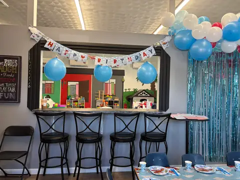 A party room decorated with a Happy Birthday banner and balloons