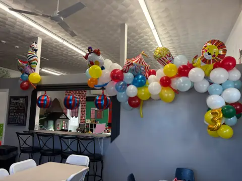 A carnival-themed balloon garland decorating a birthday party room