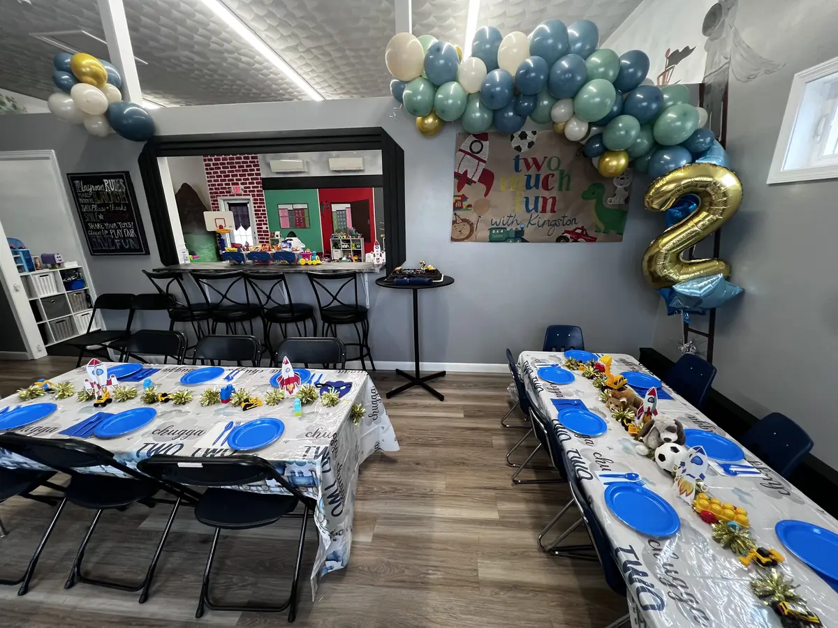 Birthday party setup with themed balloon garland, centerpieces, and party tables
