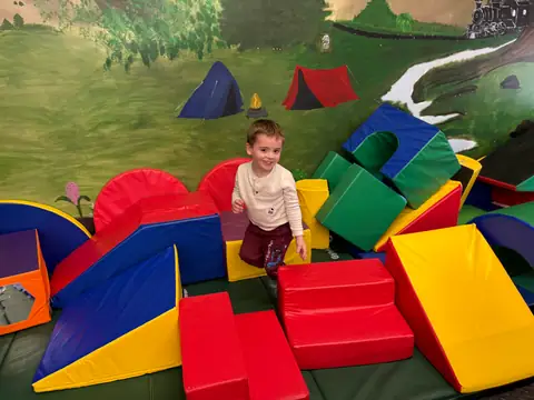 Climbing over the soft play shapes