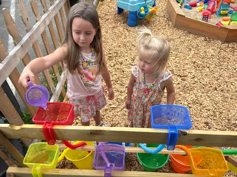 Two children at the outdoor water table